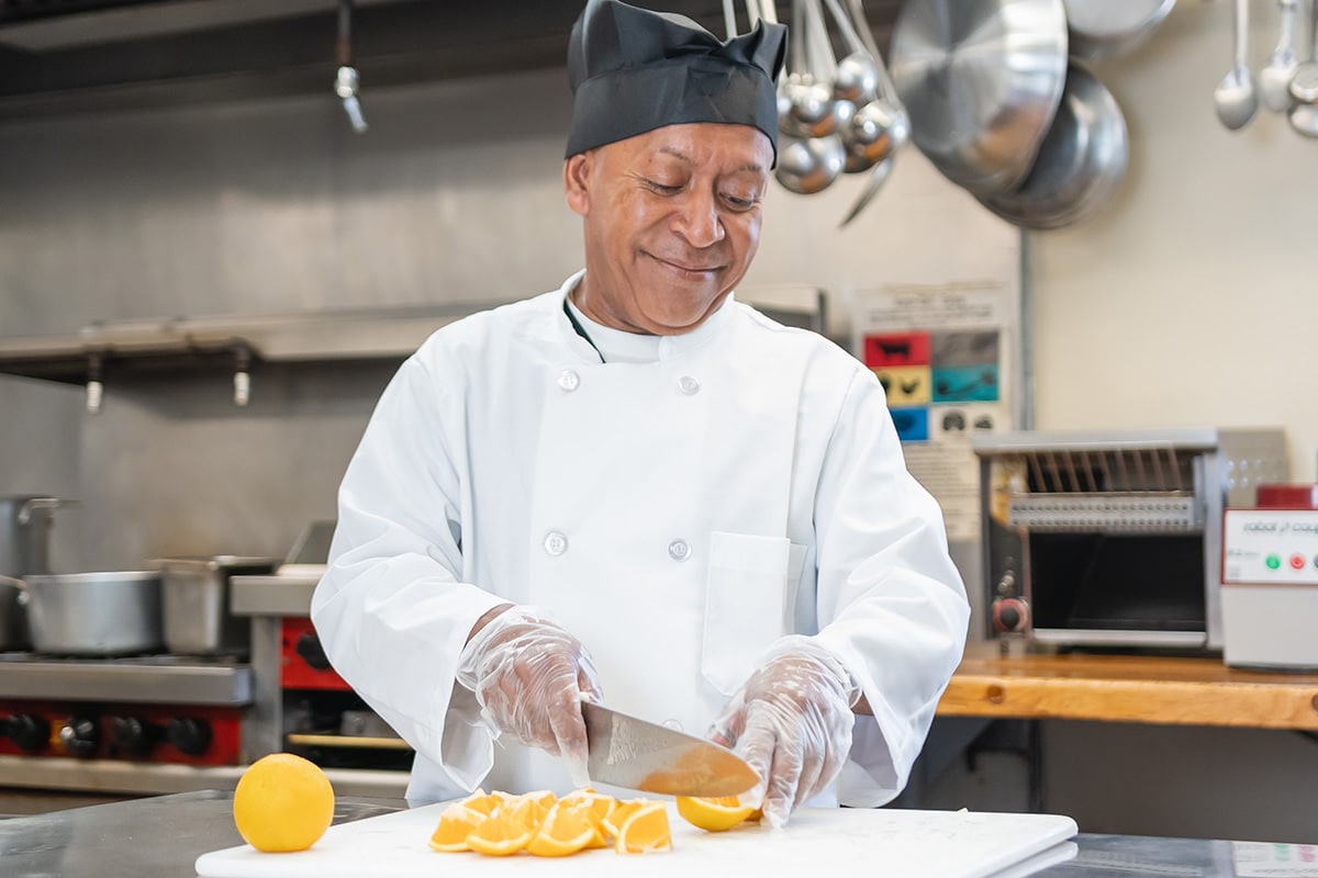 Chef chopping orange