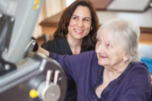 Medical worker helping woman with row machine